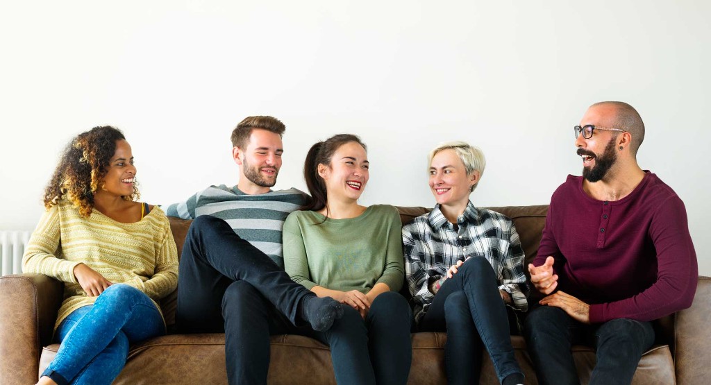 A diverse group of five people sitting on a couch, laughing together — the kind of team WebPixel Pro builds with