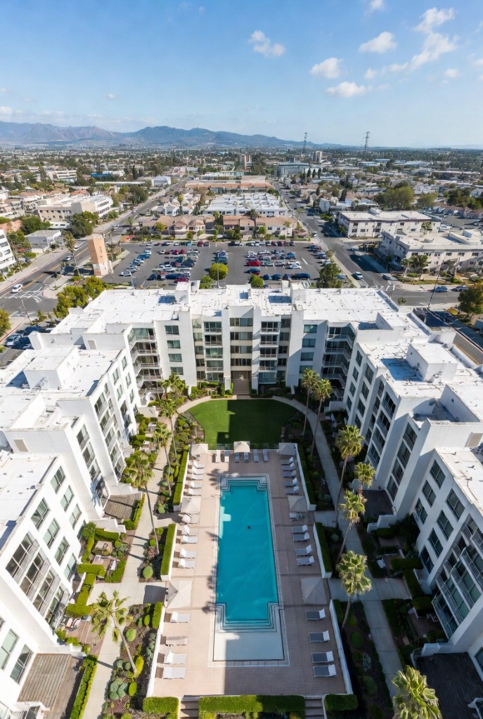 Aerial view of a managed apartment community — courtyard, pool, and surrounding neighborhood